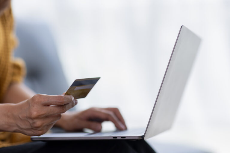 אישה משתמשת במחשב נייד וכרטיס אשראי עבור קניות מאתר אינטרנט